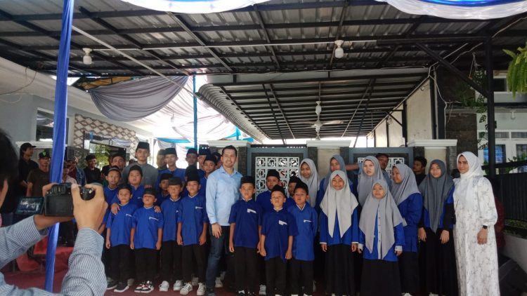 Ferdy S. Sembiring, Pembina Dewan Pimpinan Cabang Gerakan Rakyat Indonesia Bersatu (DPC GRIB) Jaya Kota Medan (tengah) diabadikan foto bersama dengan para anak Yatim dalam acara open house, Minggu (06/04/2025). (adha Lubis)