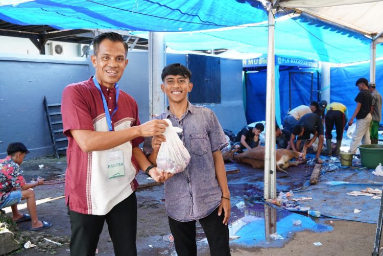 Penyerahan daging oleh panitia kurban PLN Unit Induk Distribusi Sulawesi Selatan, Sulawesi Tenggara, dan Sulawesi Barat, Agus Salim (kiri) kepada penerima manfaat, Amir (kanan) pada Jumat (06/06/2025). Amir menyampaikan rasa syukurnya atas bantuan yang sangat berarti bagi keluarganya di momen Iduladha ini. (Divkom PLN Pusat/PenaTerkini.co.id)