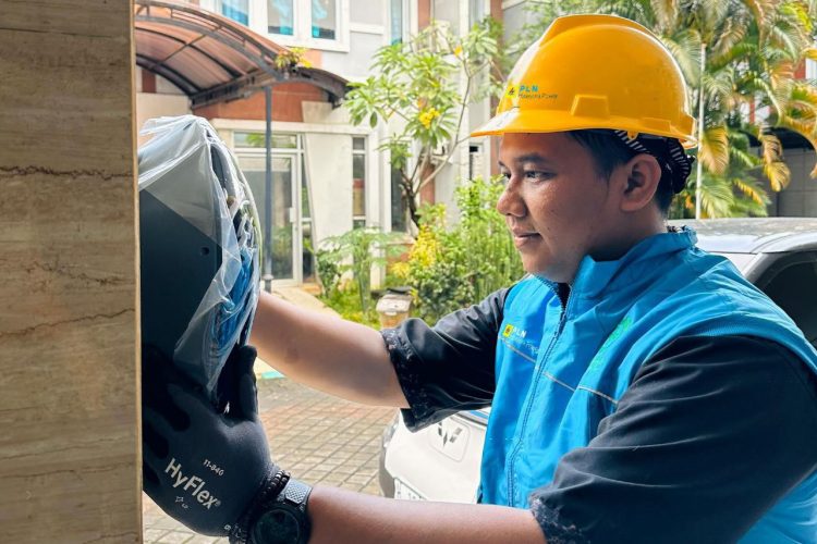 Ilustrasi petugas PLN saat melakukan pemasangan charger di rumah pelanggan untuk memudahkan pengisian kendaraan listrik di rumah melalui layanan Home Charging Services. (Divkom PLN Pusat)