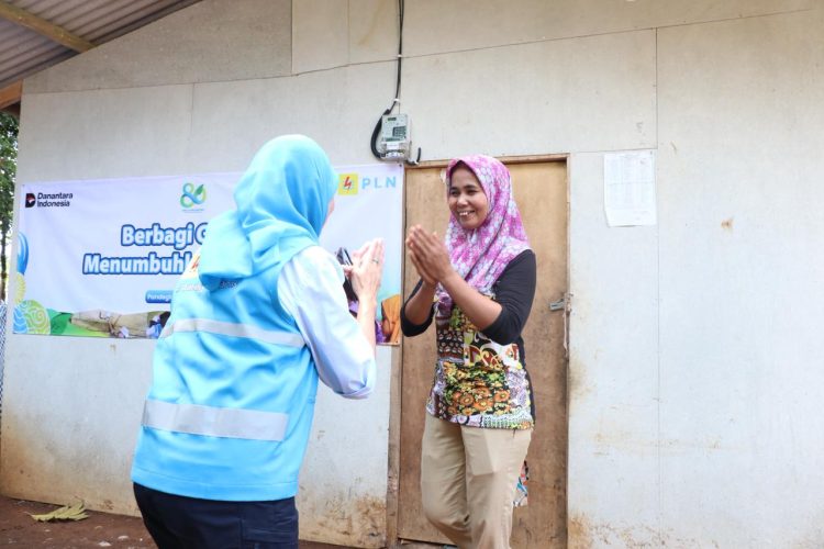 Direktur Keuangan PLN, Sinthya Roesly (kiri), disambut hangat oleh Juniah (kanan), salah satu penerima manfaat sambungan listrik gratis di Desa Pejamben, Kecamatan Carita, Kabupaten Pandeglang, Banten. Momen bahagia itu menjadi saksi pertama kalinya rumah Juniah memiliki sambungan listrik mandiri. (Divkom PLN Pusat)
