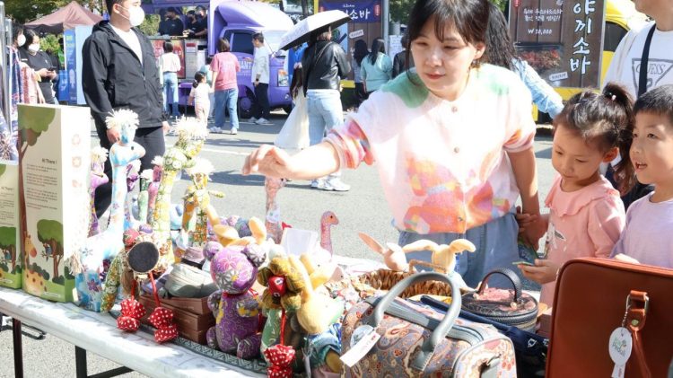 Pengunjung asal Korea Selatan bersama anak-anaknya antusias melihat dan memilih produk craft boneka batik karya UMKM binaan PLN UID Jakarta Raya di ajang Migran Arirang Multicultural Festival  (MAMF) 24 - 26 Oktober 2025 di Changwon, Korea Selatan. (Divkom PLN Pusat)