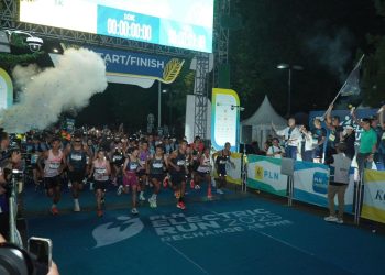 Direktur Utama PLN, Darmawan Prasodjo (belakang memegang bendera) bersama jajaran Direksi dan Komisaris PLN melepas para peserta Kategori Half Marathon PLN Electric Run 2025 di garis start. (Divkom PLN Pusat)