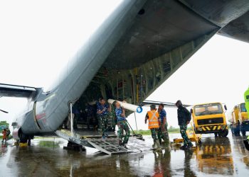 Personel TNI AU menurunkan material tower emergency dari ruang kargo pesawat Hercules di tengah kondisi hujan. Proses bongkar muat dilakukan secara cepat untuk mempercepat tahapan penyaluran ke area pemulihan kelistrikan. (Divkom PLN Pusat/ PLN UID Aceh)
