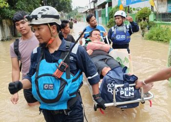 Potret aksi cepat Tim Yayasan Baitul Maal (YBM) PLN membantu evakuasi warga yang terdampak banjir di Medan. (Divkom PLN Pusat)
