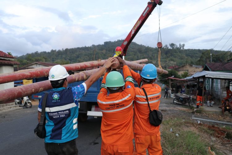 Petugas PLN bahu membahu dalam memobilisasi tiang listrik untuk melakukan pemulihan jaringan akibat bencana. (Divkom PLN Pusat/ PenaTerkini.co.id)