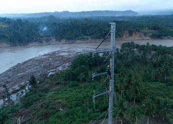 Petugas PLN ketika melakukan penyambungan kabel transmisi Saluran Udara Tegangan Tinggi (SUTT) 150 kilovolt (kV) Arun - Bireuen di atas emergency tower yang telah didirikan. (Divkom PLN Pusat/ PenaTerkini.co.id)
