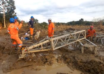 Di tengah medan yang berlumpur, petugas PLN melakukan perakitan tower darurat di jalur transmisi Langsa-Pangkalan Brandan. (Divkom PLN Pusat)