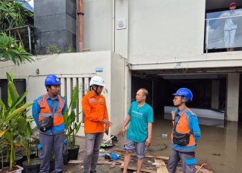 Ilustrasi petugas PLN melakukan koordinasi dan edukasi keamanan listrik dengan salah satu pelanggan terdampak banjir. (Divkom PLN Pusat)